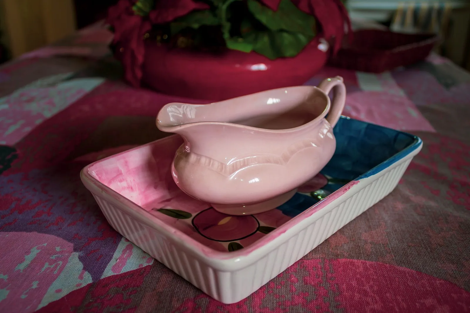 Vaaleanpunainen kastikekulho tarjoiluvadilla