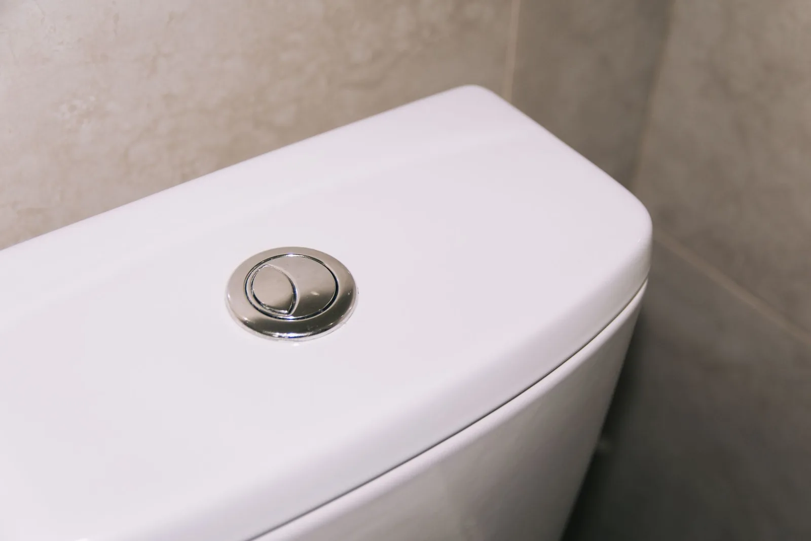 WC:n vesisäiliön kansi ja huuhtelunappi